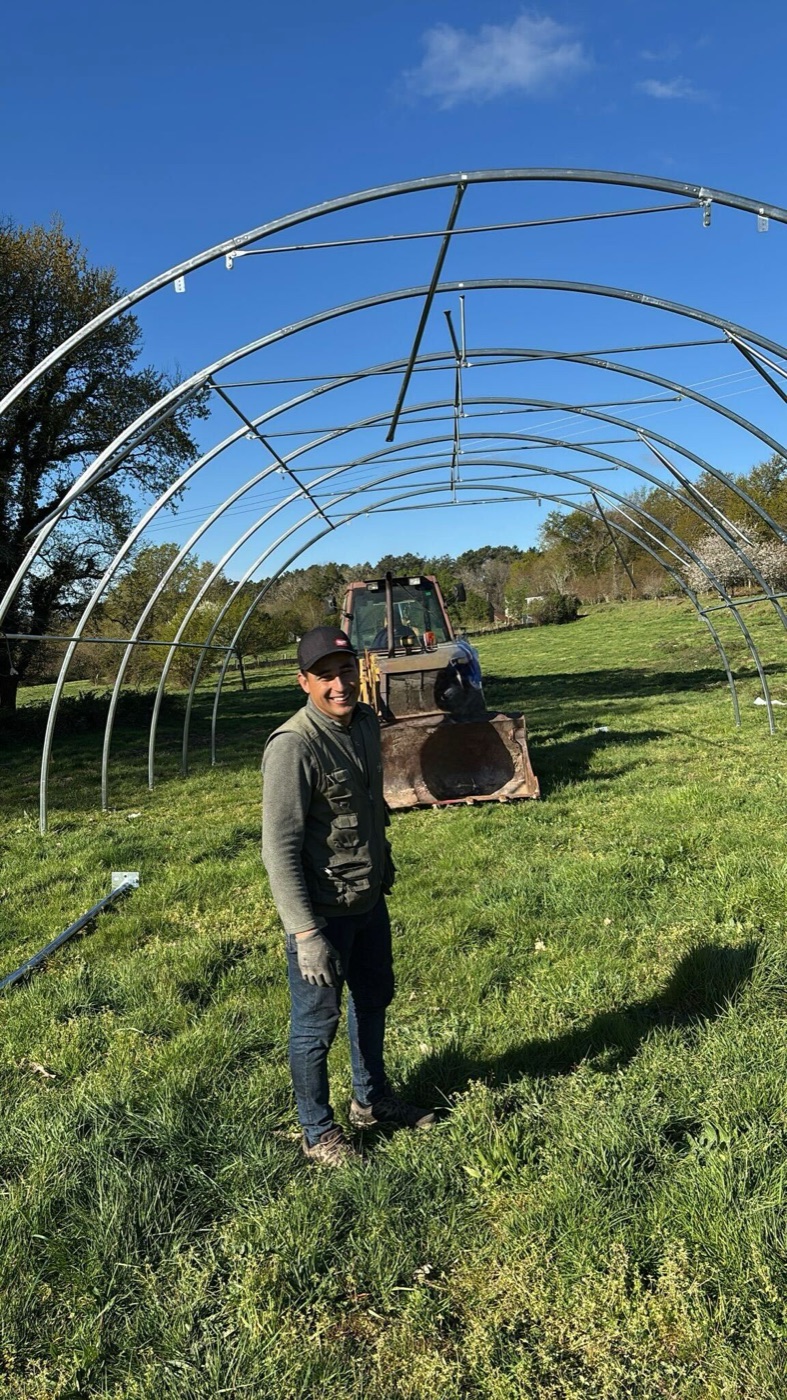 Installer in front of the steel-arch frame of an arched building